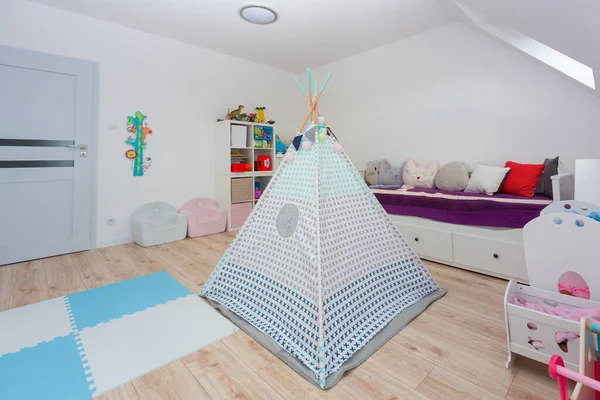 Children playroom with toys and a tent