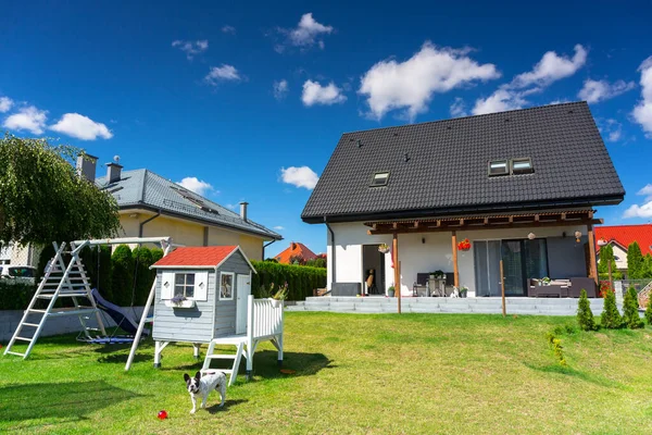 A modern single family house with a garden in summer scenery