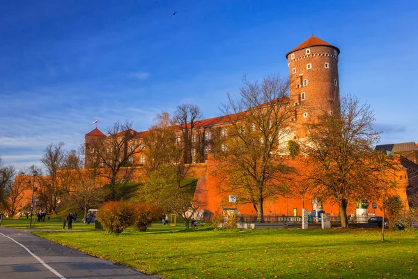 Krakow, Polonya - 12 Kasım 2017: İnsanlar gün batımında Krakow 'daki Royal Wawel Şatosu' nda yürüyorlar. Polonya 'nın en büyük kalelerinden biri olan şato Krakow' da yer almaktadır.