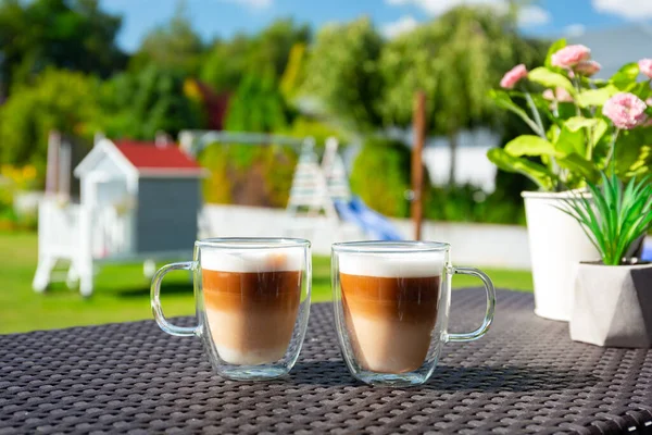 在阳光灿烂的花园露台桌上的两杯咖啡 — 图库照片