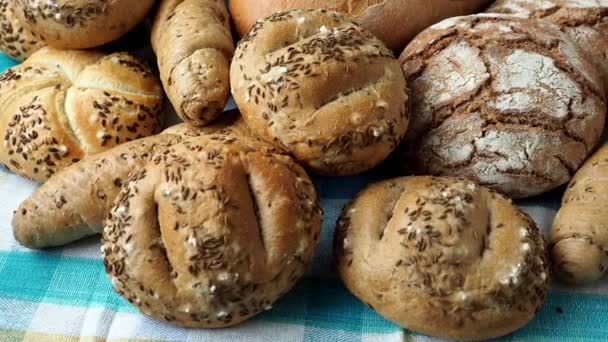 なパンのヒープ ロール塩とキャラウェイ シードを胡麻を振りかけた 発酵生地から新鮮な素朴なパン — ストック動画