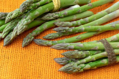 Taze kuşkonmaz officinalis turuncu zemin üzerine izole. Ham Bahçe kuşkonmaz kaynaklanıyor.