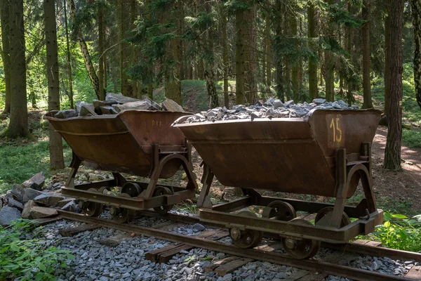 Mining cart with stones. Old and abandoned mining cart in forest.