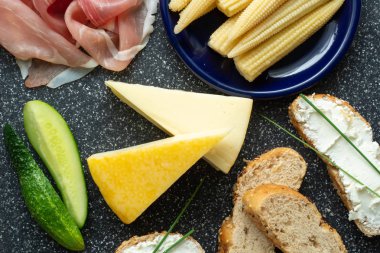 Soğuk meze. Soğuk kesim. Baharatlı gıda üzerine siyah arka plan, üstten görünüm.