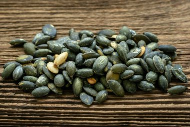 Kabak çekirdeği deniz tuzu kullanarak terbiyeli. Ahşap masa üzerinde kabak çekirdeği.