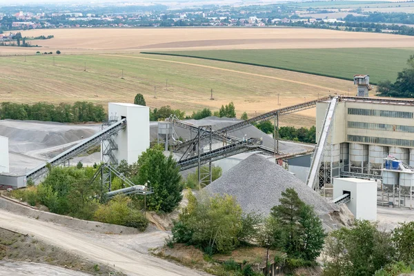 Big silos, belt conveyors and mining equipment in a quarry. Quarrying of stones for construction works. Mining industry in quarry.