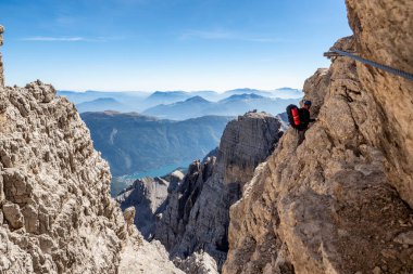 İtalya 'daki Dolomitler Dağları' nın nefes kesici manzarasında, Via Ferrata 'da bir erkek dağcı. Seyahat macera konsepti.