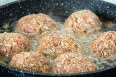 Tavada kızarmış hamburger var. Yağda kızartılmış yemek.