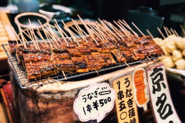 Izgara unagi veya tatlı su yılan balığı sopa üzerinde Nishiki pazarı, Kyoto, Japonya, sokak gıda olarak