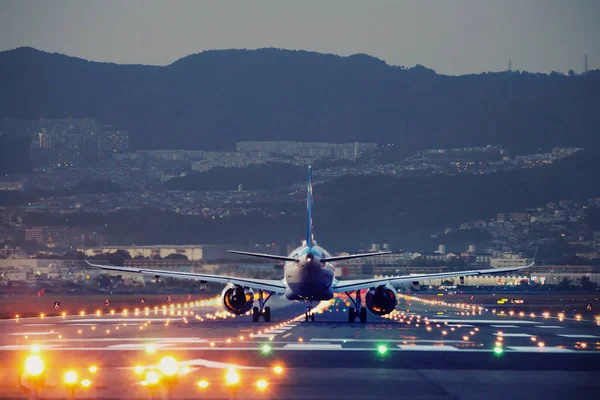 Pouso de avião grande durante a hora azul — Fotografia de Stock