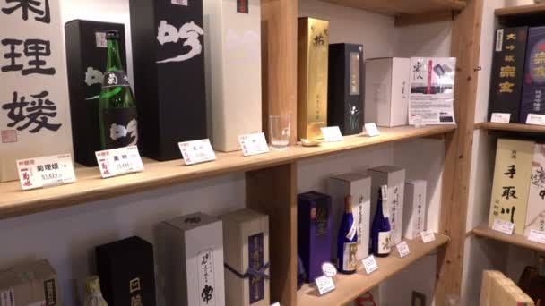Бутылки сакэ в магазине на рынке Омичо, Канадзава, Япония — стоковое видео