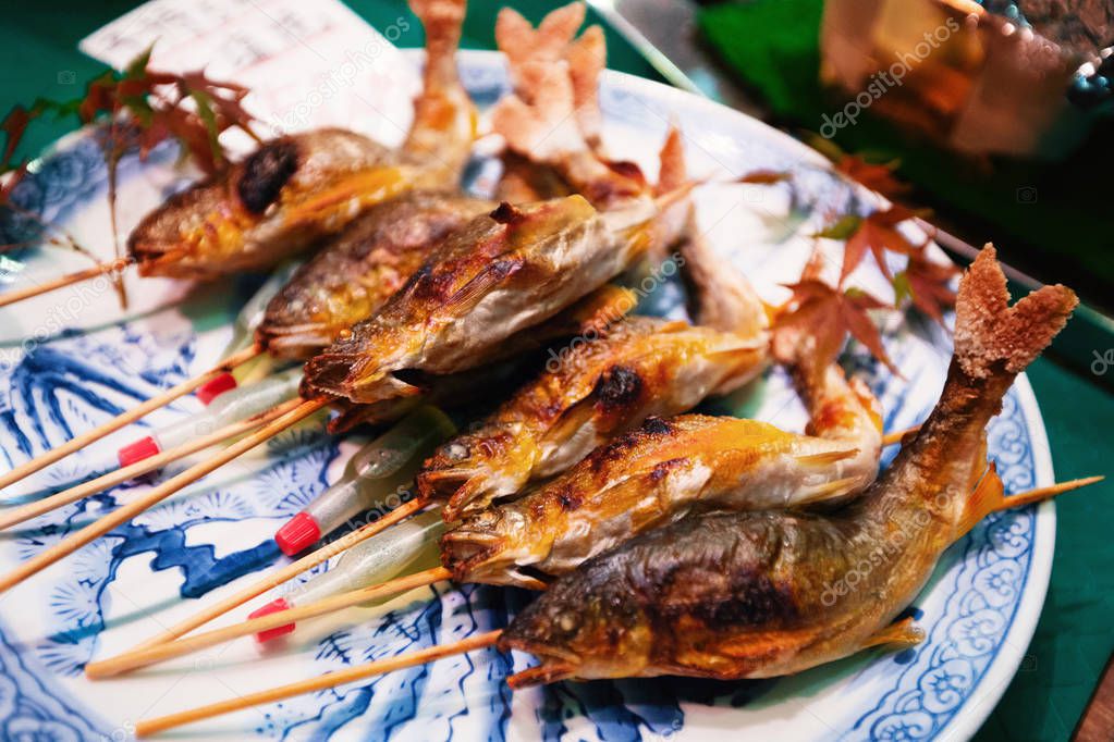 Grilled fishes on sticks as street food at Nishiki market, Kyoto