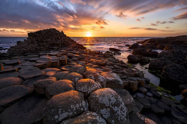 Zachód słońca nad bazaltowymi kolumnami Giants Causeway, County Antrim, Northern Ireland — Zdjęcie stockowe