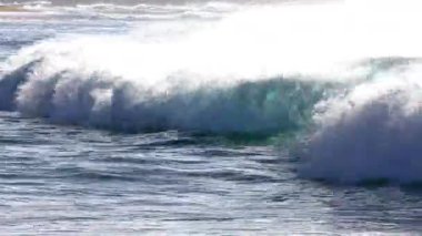 Hawaii, Oahu 'da kimliği belirsiz bir adamla kumsalda dalgalar çarpışıyor.