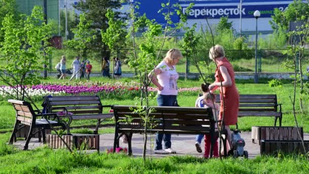 Moskva, Ryssland - 15 maj. 2018. mödrar med barn på boulevard nära bänkar i Norrtälje — Stockvideo