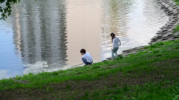 Moskou, Rusland - 15 mei. 2018. de kinderen spelen in de buurt van de vijver in 15e district van Zelenograd — Stockvideo