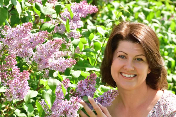 Woman near blooming lilac. — Stock Photo, Image