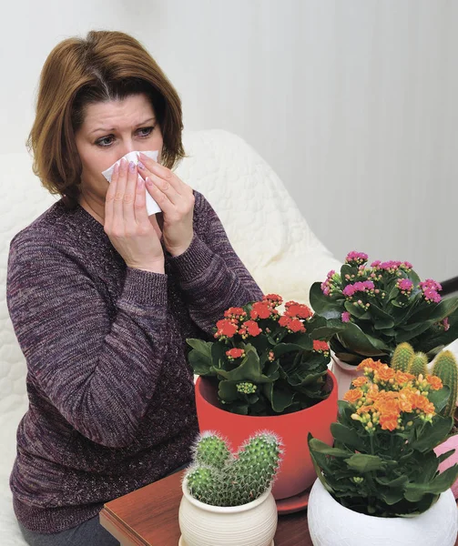 Kobieta z alergicznym nieżytem nosa z rośliny rosnące w pomieszczeniach — Zdjęcie stockowe