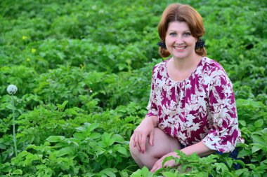 Yaz aylarında patates sahada oturan kadın