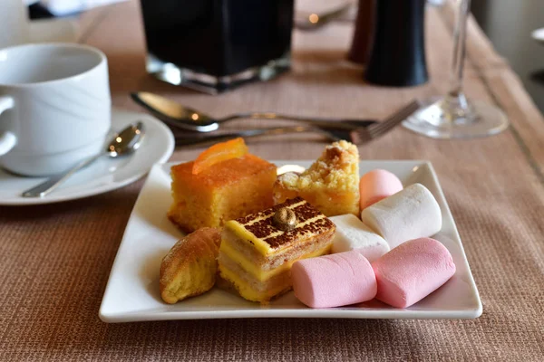 Ένα Σύνολο Των Γλυκών Ένα Λευκό Πιάτο Στο Τραπέζι Στην — Φωτογραφία Αρχείου