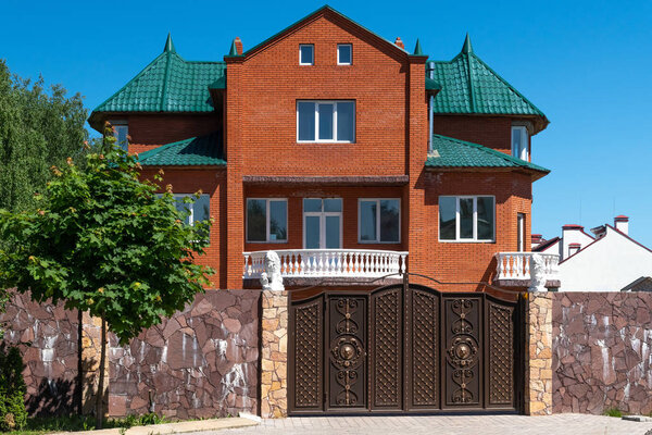 Modern private house behind the fence in a summer