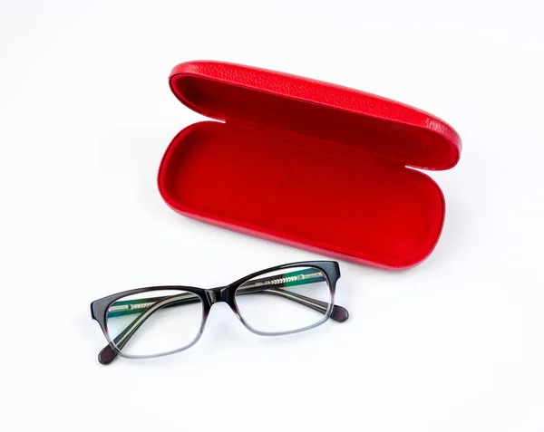 Glasögon och röda fall på en vit bakgrund — Stockfoto