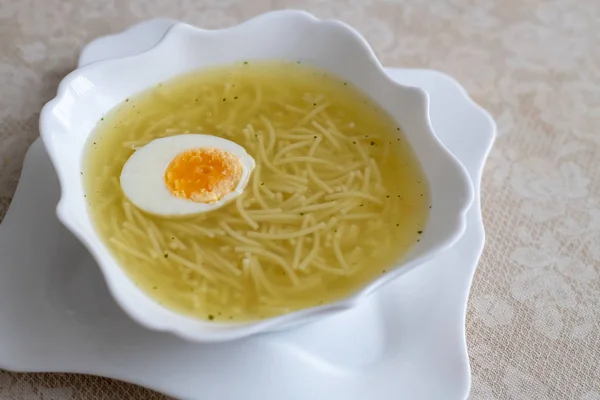 Macarrão apetitoso em um caldo de galinha com ovo cozido — Fotografia de Stock