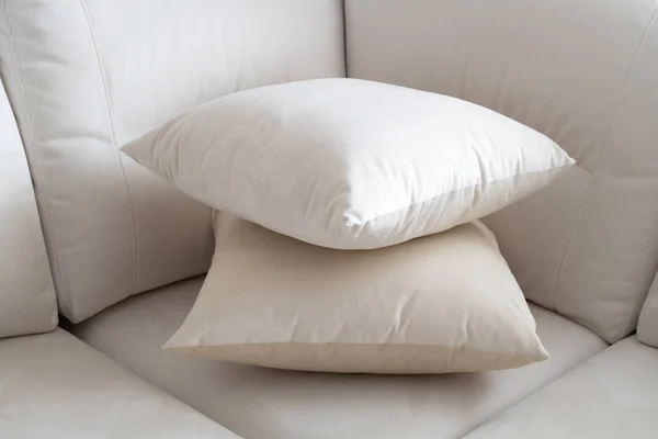 Две белые подушки на светлом диване — стоковое фото