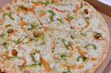 Deniz ürünleri ve sebze karton kutuda pizza