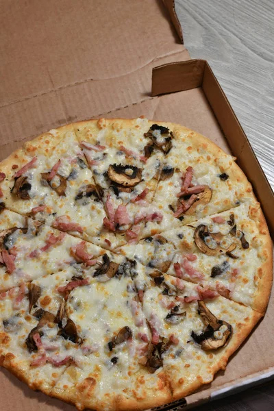 Pizza with mushrooms and ham in carton box — Stock Photo, Image