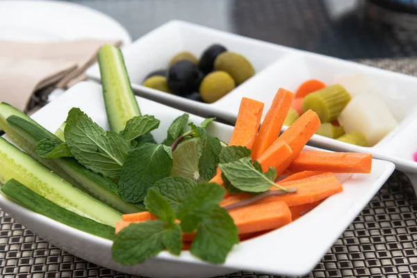 Fresh and a pickled vegetables on plates — Stock Photo, Image