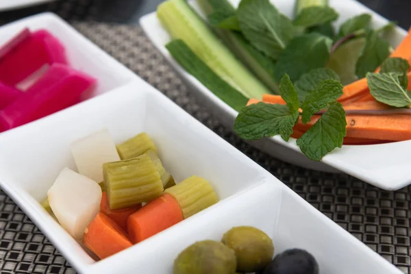 Verduras frescas y en vinagre en platos — Foto de Stock