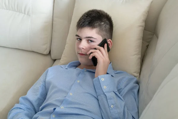 Teenager Parlare sul cellulare sdraiato sul divano — Foto Stock