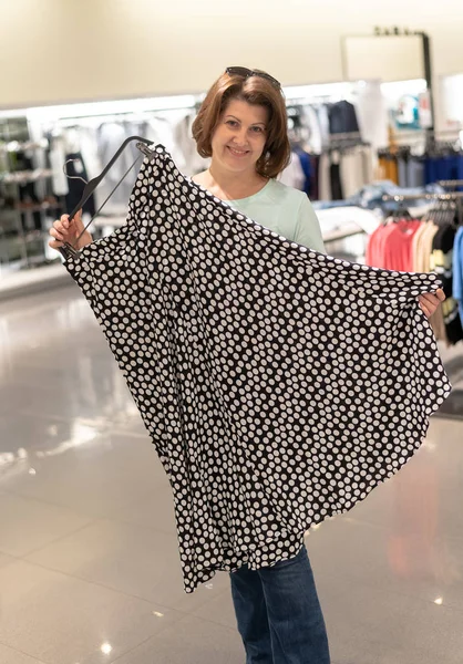 Женщина выбирает юбку в магазине — стоковое фото
