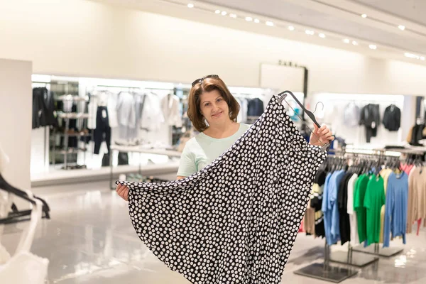 La Mujer elige la falda en la tienda — Foto de Stock