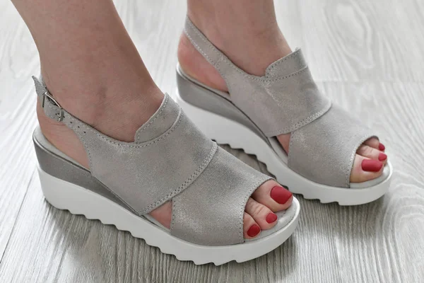 De Womens benen in de zomer witte sandalen — Stockfoto