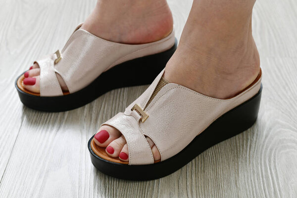 The Womens legs in summer white clogs