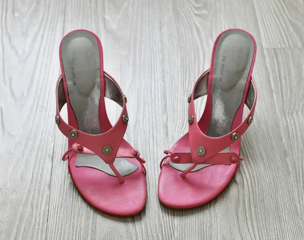 Stare różowe sandały na obcasie stoją na podłodze — Zdjęcie stockowe
