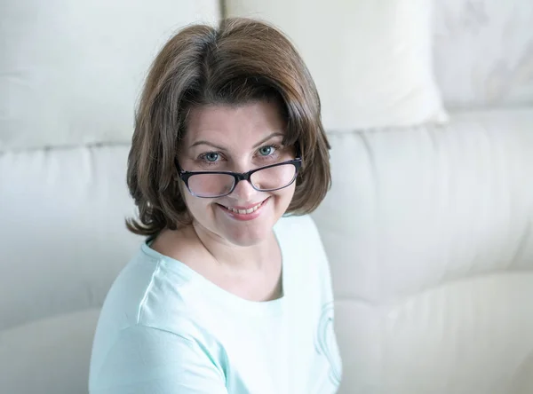 Portret van een vrouw met glazen in huis interieur — Stockfoto