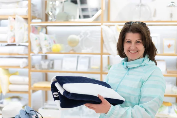 La mujer elige una toalla en la tienda — Foto de Stock