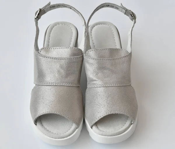 Сірі літні жіночі сандалі на білому тлі — стокове фото