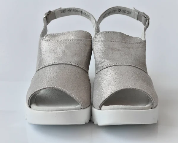 Сірі літні жіночі сандалі на білому тлі — стокове фото