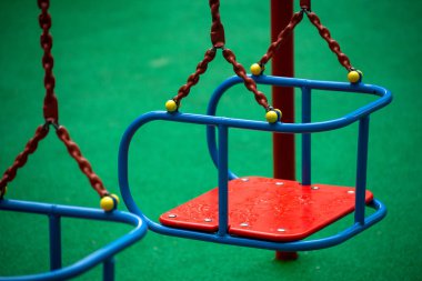 Oyun alanında boş bir kırmızı salıncak