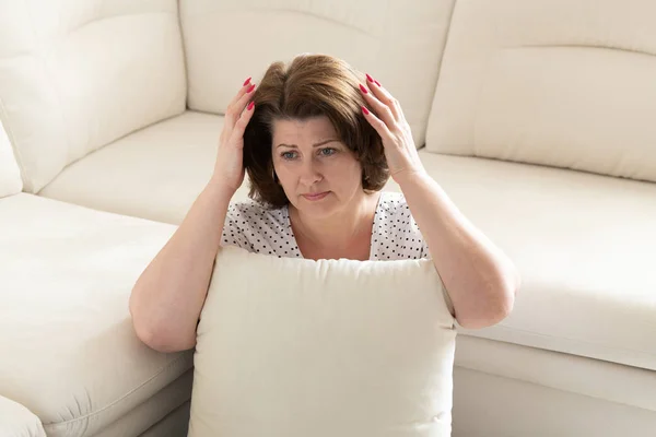 Erwachsene Frau mit Migräne hält ihren Kopf — Stockfoto