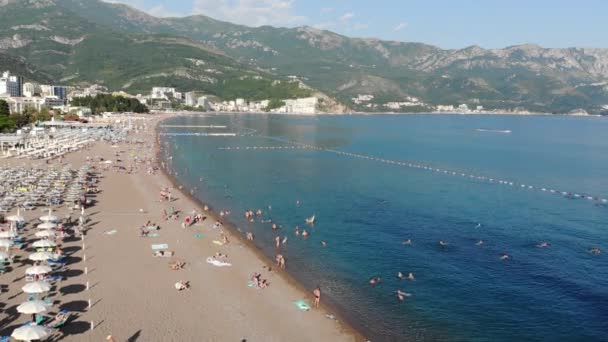 Becici, Montenegró-június 12,2019. Gyönyörű felülnézet a strandon emberekkel. — Stock videók