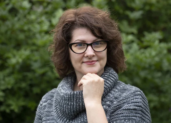 Portrait of curly woman in red glasses on nature — Stock Photo, Image