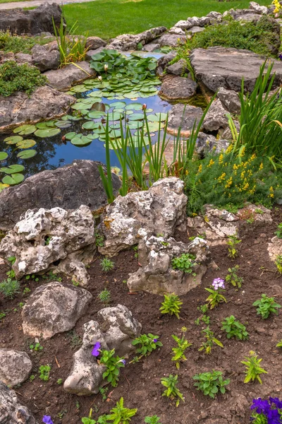 Pequeño hermoso jardín con un estanque artificial en verano — Foto de Stock