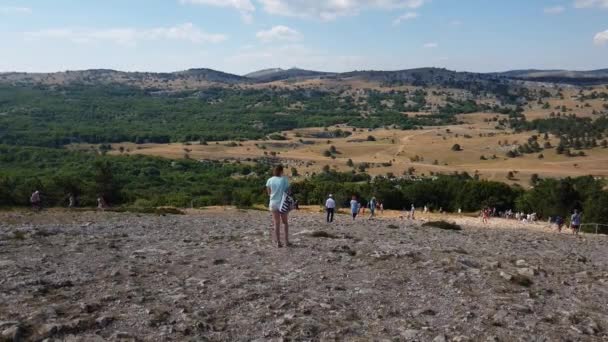 Ai-Petri, Krím - 2019. július 5. A turisták az Ai-Petri hegy legmagasabb pontján sétálnak. — Stock videók