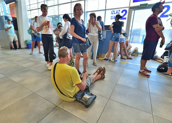 Tivat, Montenegro - Oct 10. 2019. People sitting on the floor in a crowded Departure hall of international airport Tivat — Stock Photo, Image