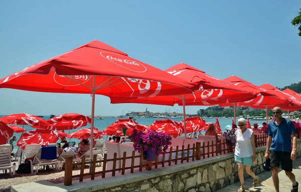 Будва, Черногория - 13 июня 2019 года. Городской пляж в курортной зоне с красными пумбреллами с брендом Coca Cola — стоковое фото